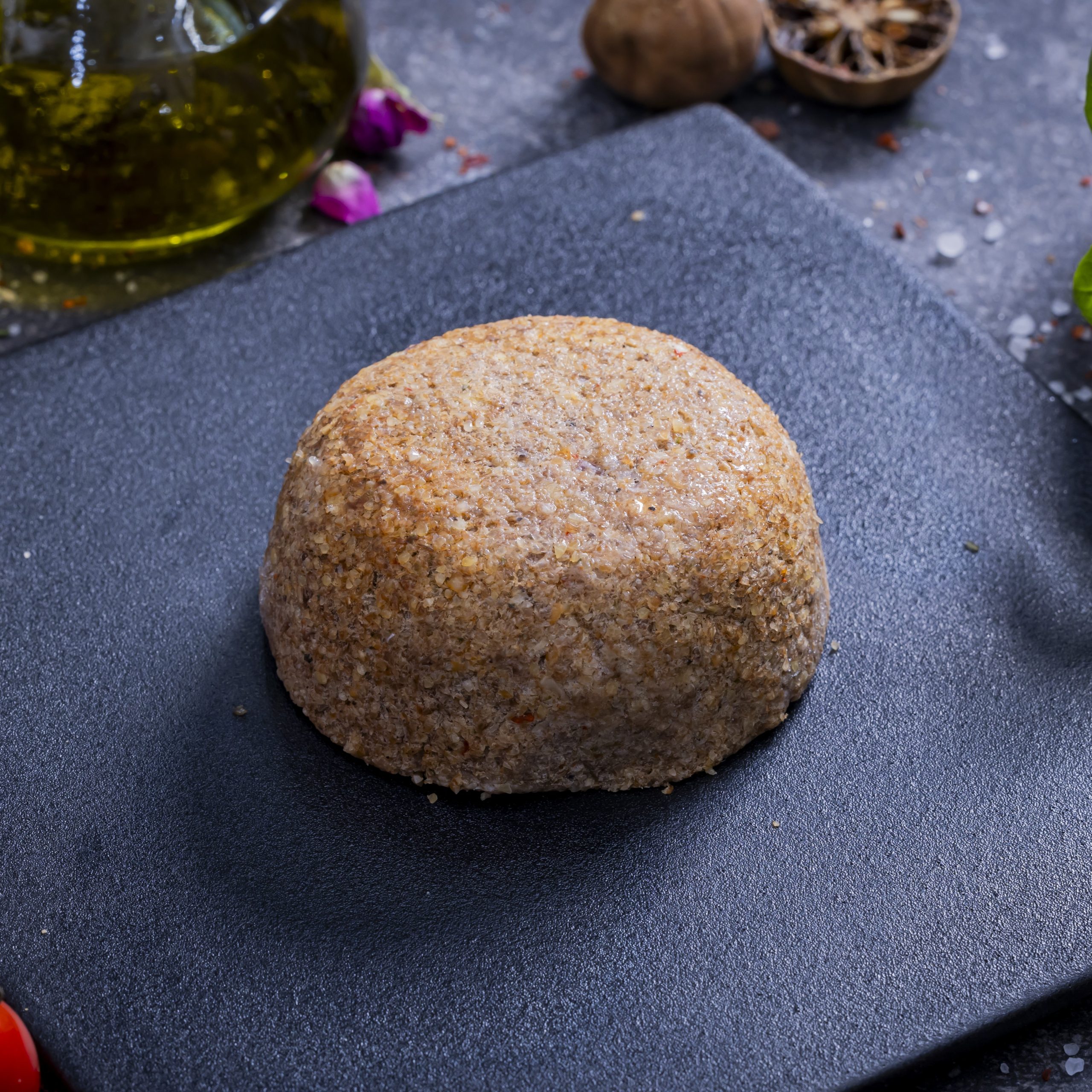 Kebbeh Mashwieh - <p>Cracked bulgur blended with minced meat, onions, and spices, stuffed with fat, nuts, and pomegranate molasses, shaped into savory discs</p>