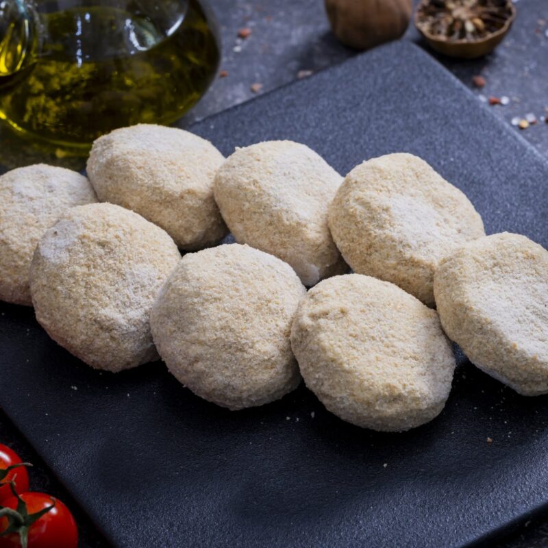 Breadcrumb-coated minced meat croquettes on a slate board with olive oil and tomatoes - The Meat Master Butchery