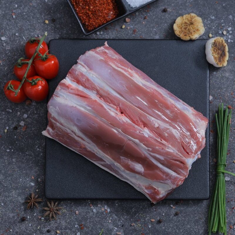 Fresh raw lamb ribs rack on a slate board with cherry tomatoes and spices - The Meat Master Butchery