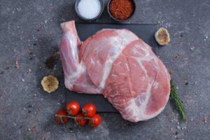 Two whole raw lamb legs on a slate board with rosemary - fresh from The Meat Master Butchery