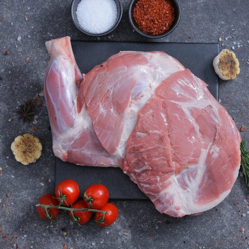 Two whole raw lamb legs on a slate board with rosemary - fresh from The Meat Master Butchery