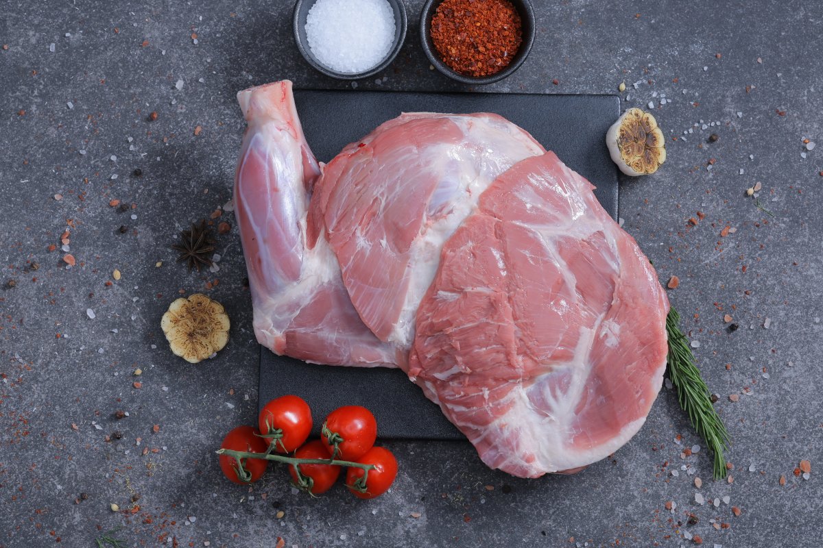 Two whole raw lamb legs on a slate board with rosemary - fresh from The Meat Master Butchery