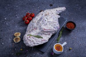 Whole raw chicken marinated in herb yogurt sauce on a slate board - The Meat Master Butchery