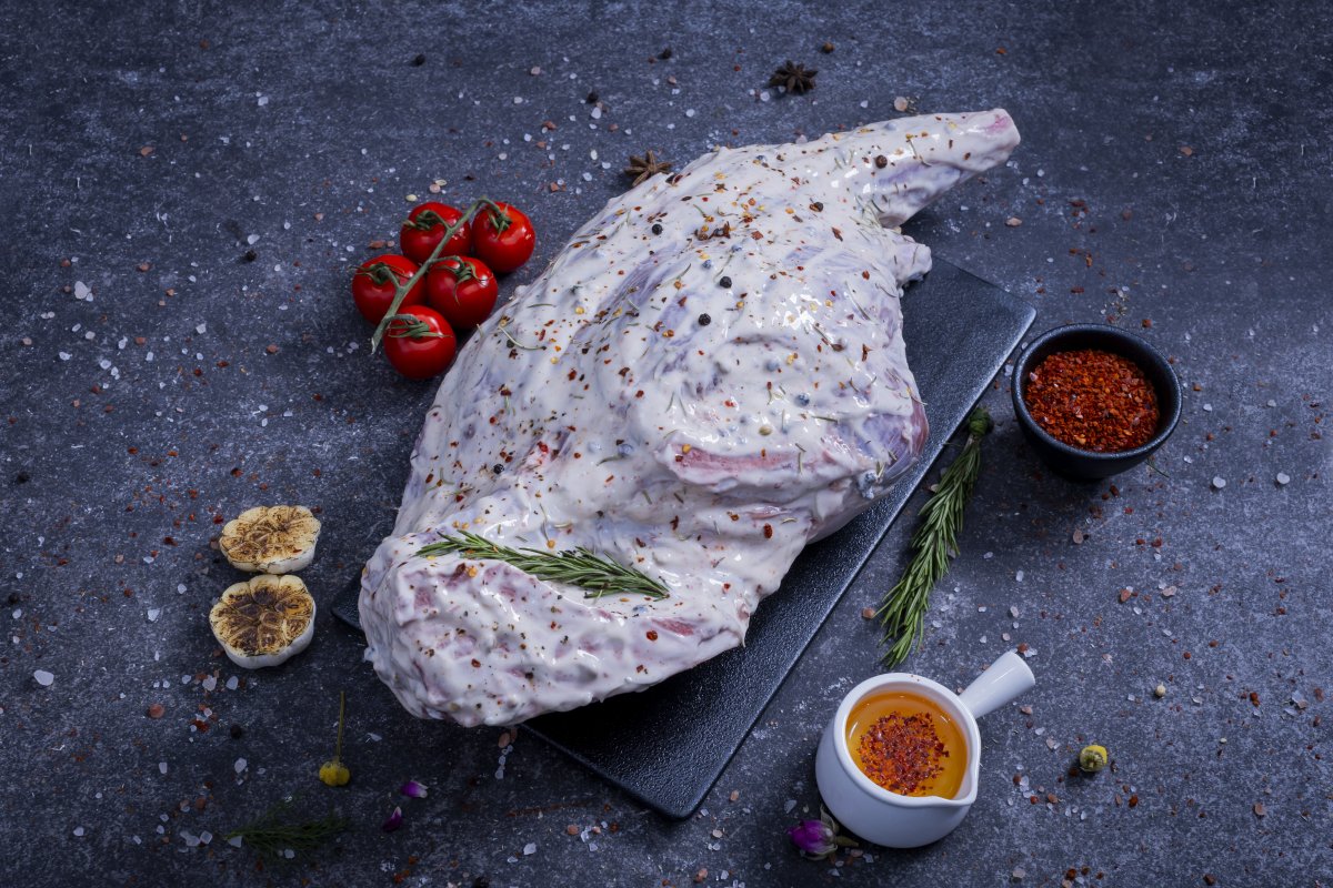 Whole raw chicken marinated in herb yogurt sauce on a slate board - The Meat Master Butchery