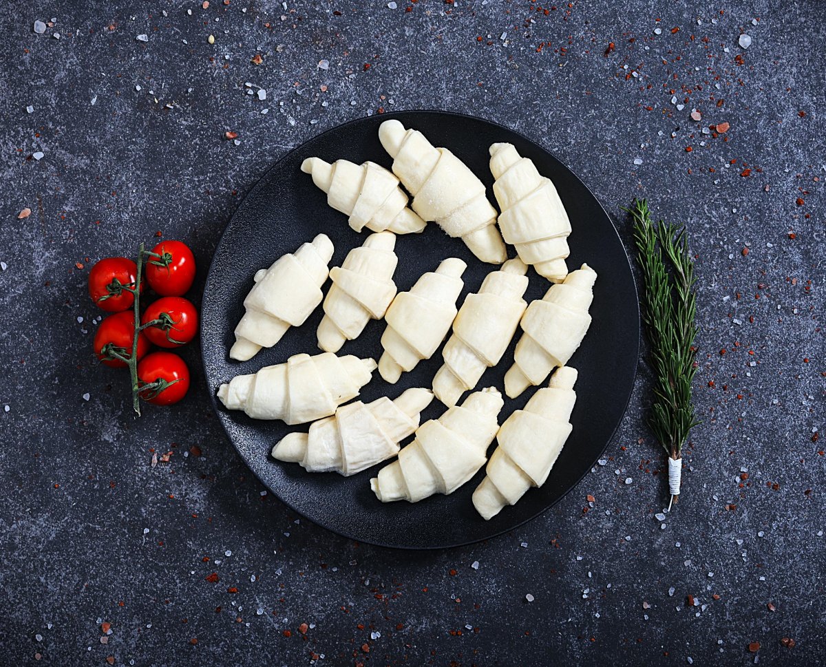 Raw unbaked mini croissants arranged on a black plate - fresh bakery at The Meat Master Butchery