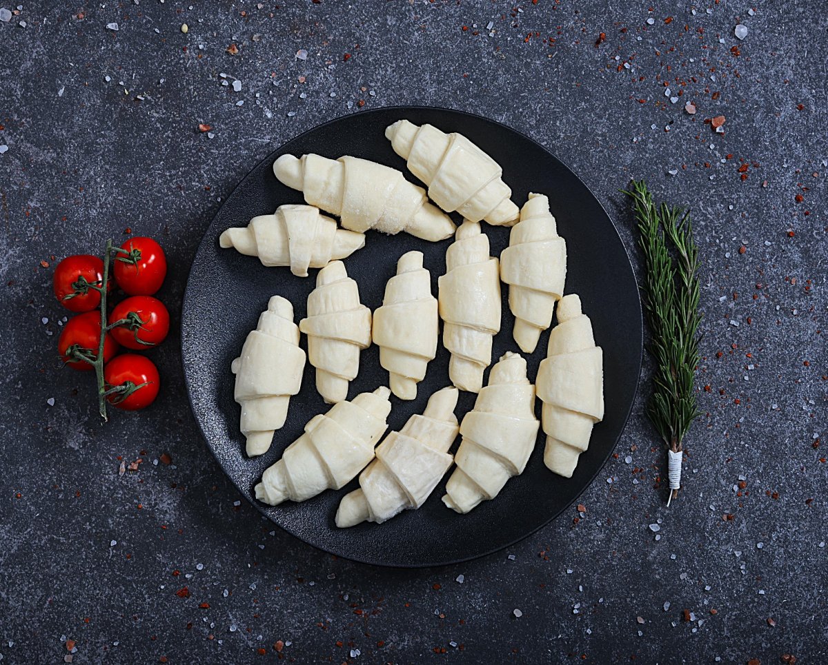 Mini raw croissants ready to bake on a black plate different angle - fresh bakery at The Meat Master Butchery