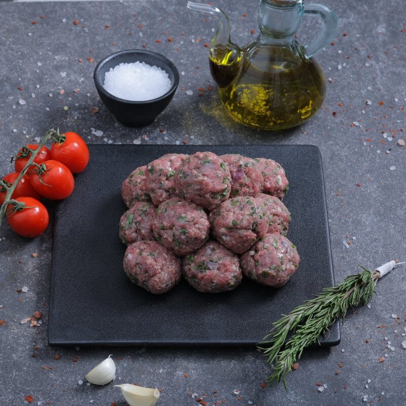 Raw herb-spiced minced meat balls on a slate board with olive oil - fresh from The Meat Master Butchery