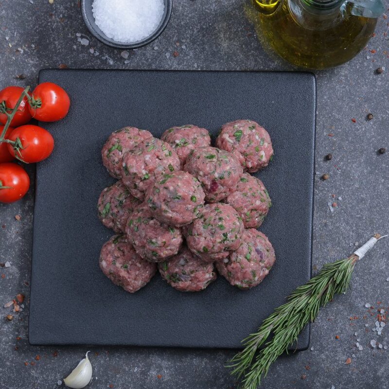 Raw spiced meat balls overhead shot on a slate board - fresh from The Meat Master Butchery