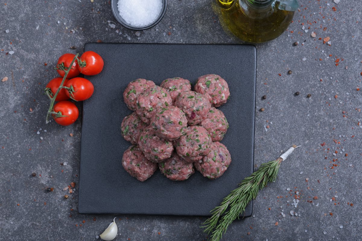 Raw spiced meat balls overhead shot on a slate board - fresh from The Meat Master Butchery
